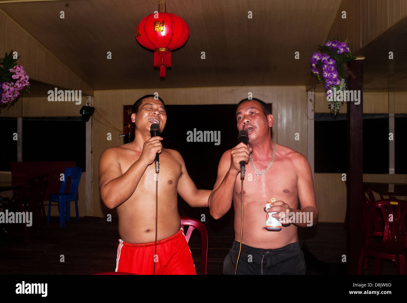 Halong Bay, Vietnam - Men playing karaoke on a houseboat Stock Photo