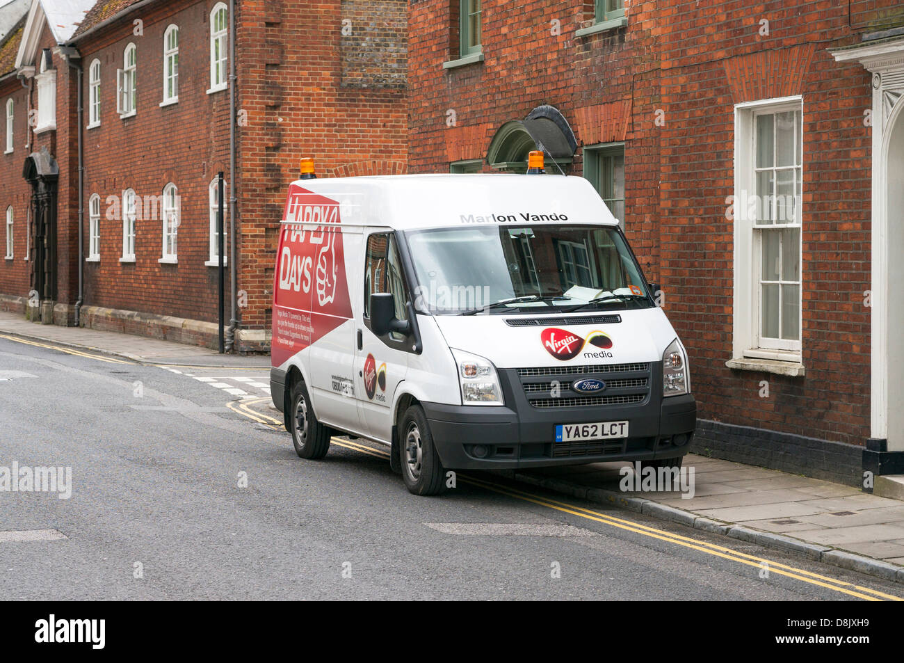 Virgin Media Ford Transit van parked on double yellow lines and pavement sidewalk Stock Photo
