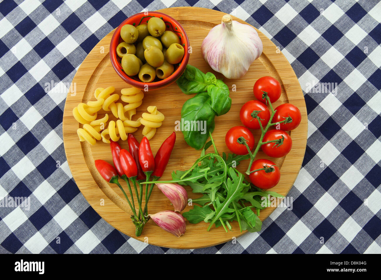 Italian ingredients on wooden board on checkered tablecloth Stock Photo