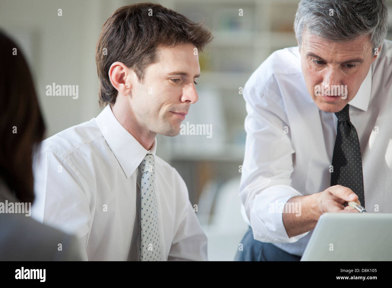 Business associates collaborating with laptop computer Stock Photo