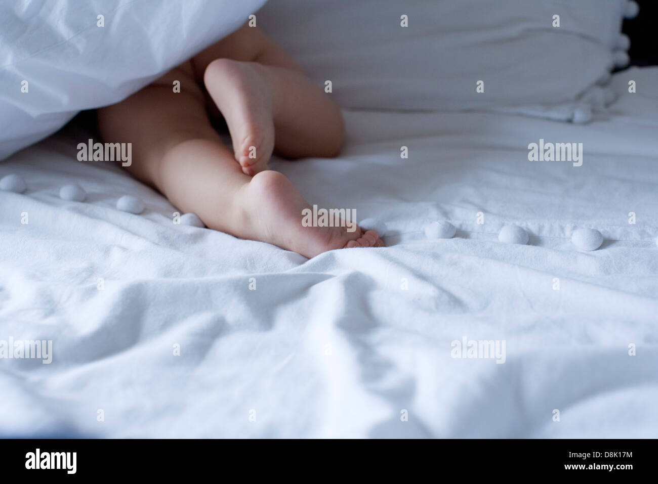 Baby crawling under duvet, cropped Stock Photo Alamy