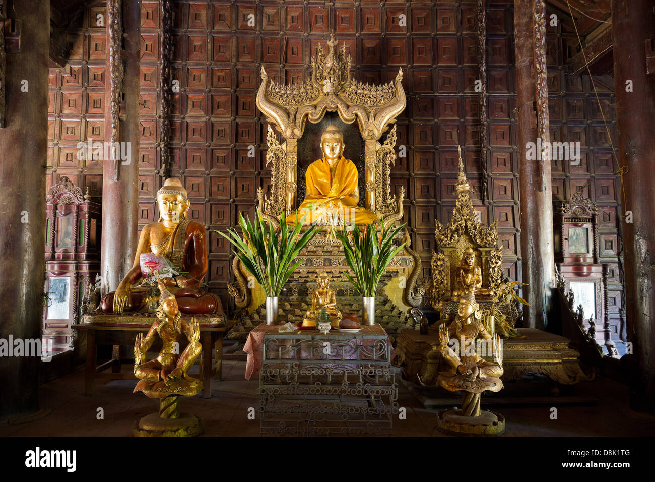 Interior with golden main buddha of historic teak wood temple Shwe in