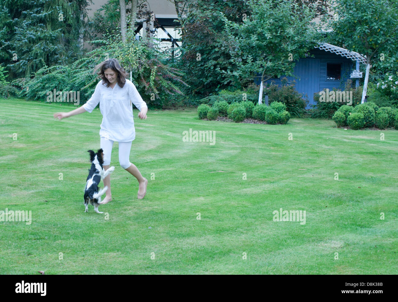 Girl playing with pet dog in backyard Stock Photo - Alamy
