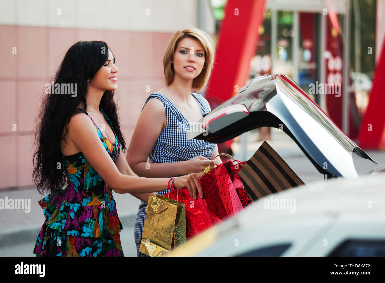 Two young women with a shopping bags Stock Photo - Alamy
