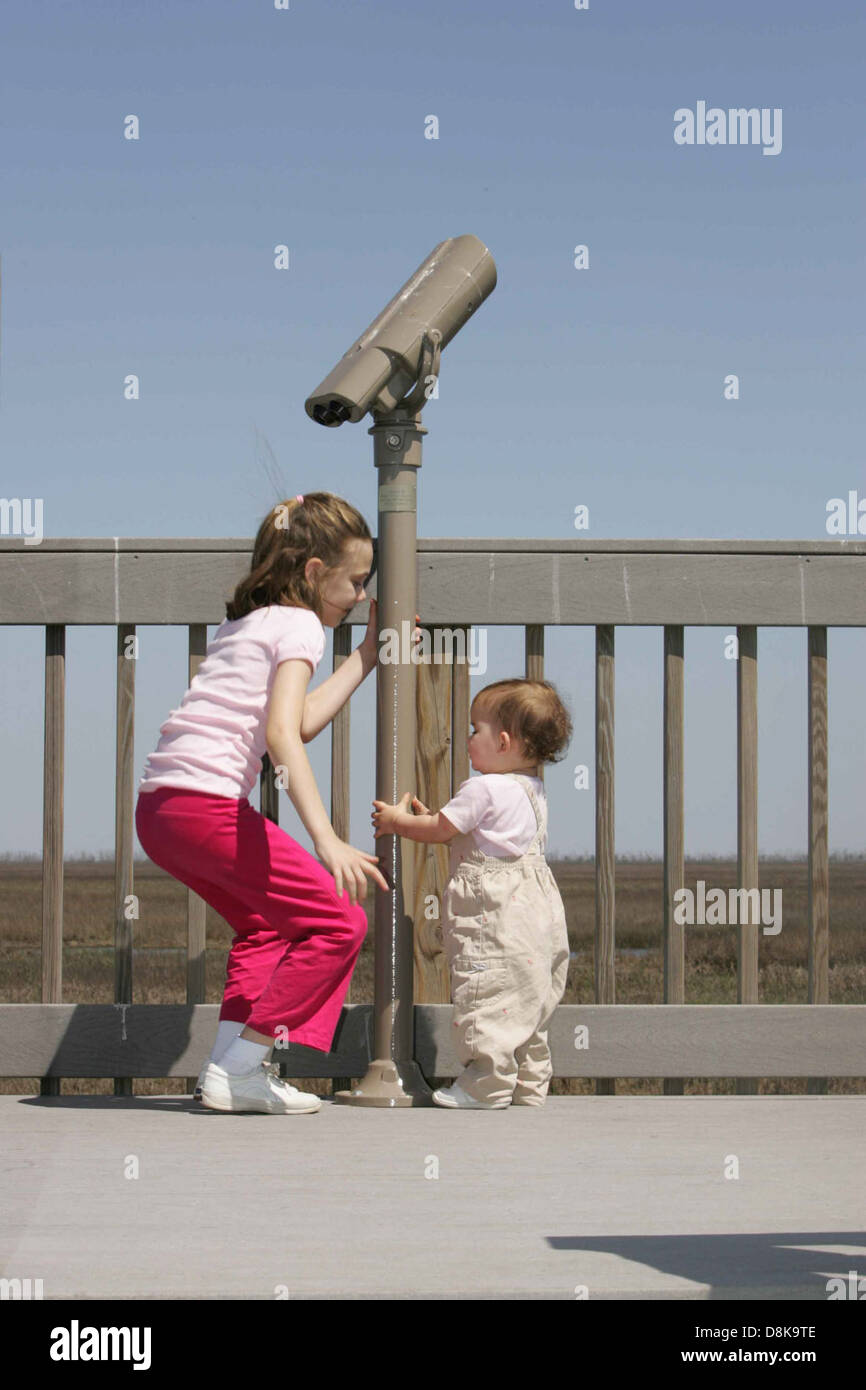 Two children play outside under a bright sun, enjoying the warmth and ...