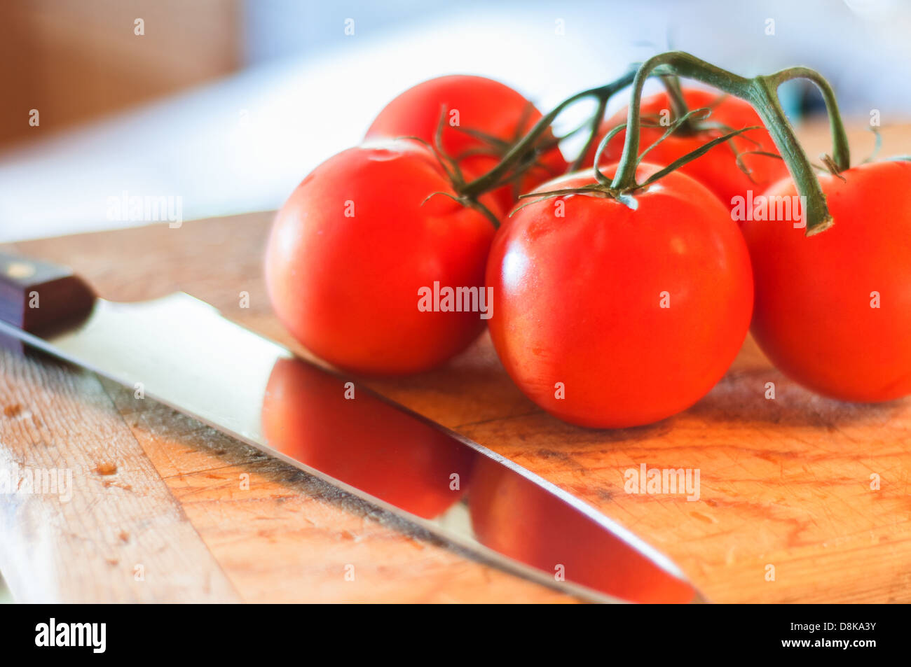 Tomatoes on a cutting board ready to slice and eat Stock Photo - Alamy