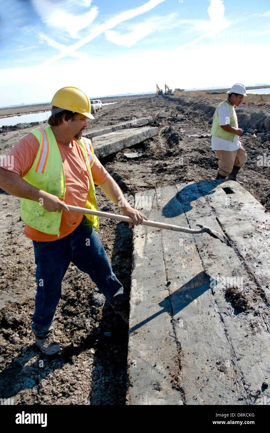 Construction workers are seen working on a road, laying asphalt or ...