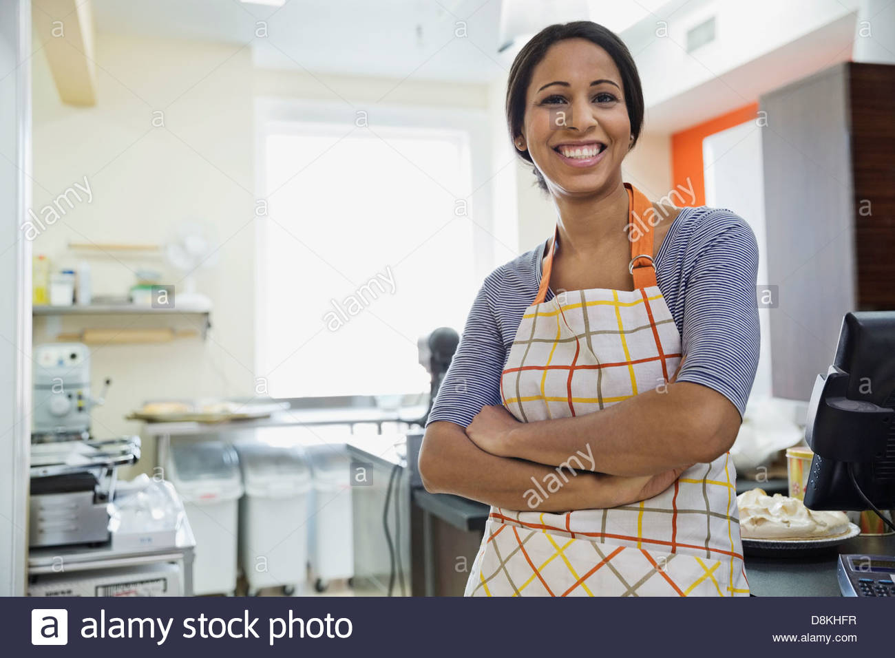 Portrait of smiling woman baker standing in bakery Stock Photo