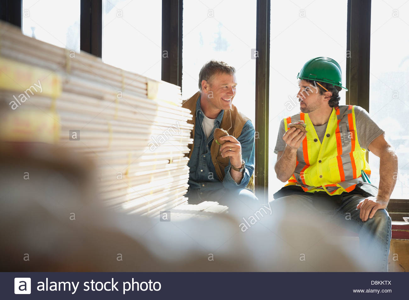 Tradesman and foreman taking lunch break at construction site Stock Photo