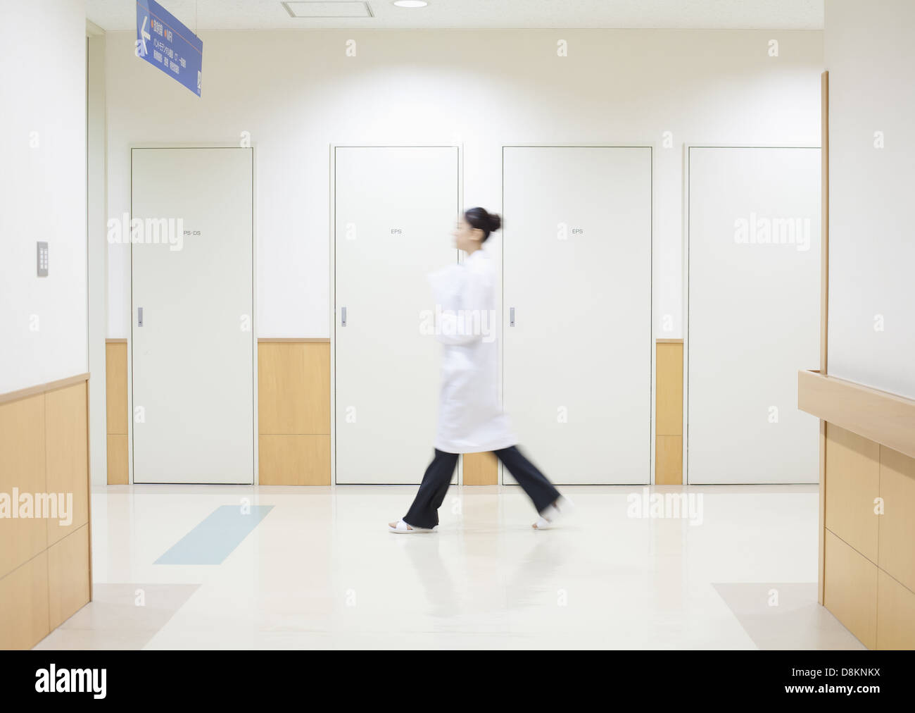 Woman doctor walking along corridor Stock Photo