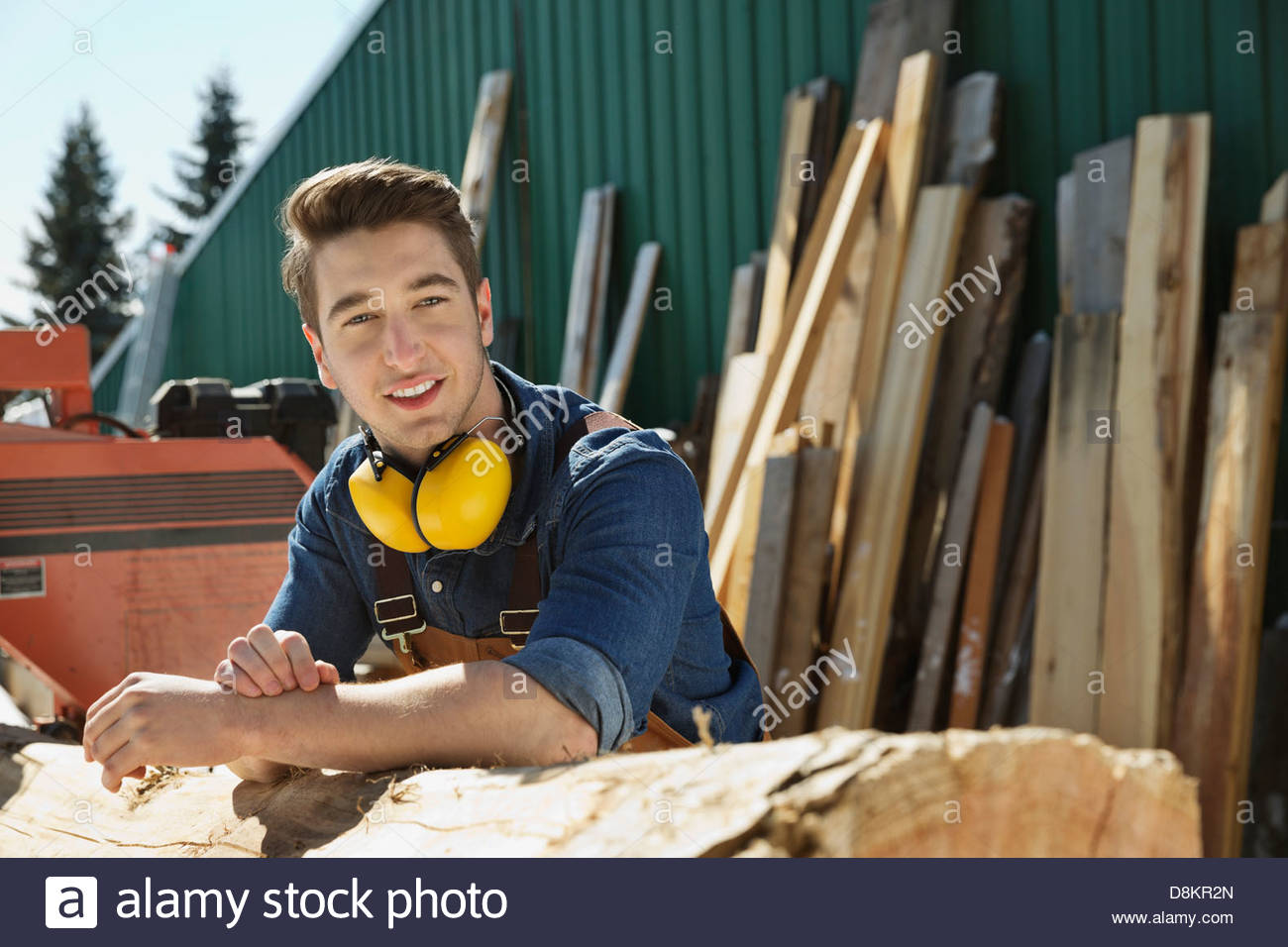Portrait of woodworker leaning on log Stock Photo