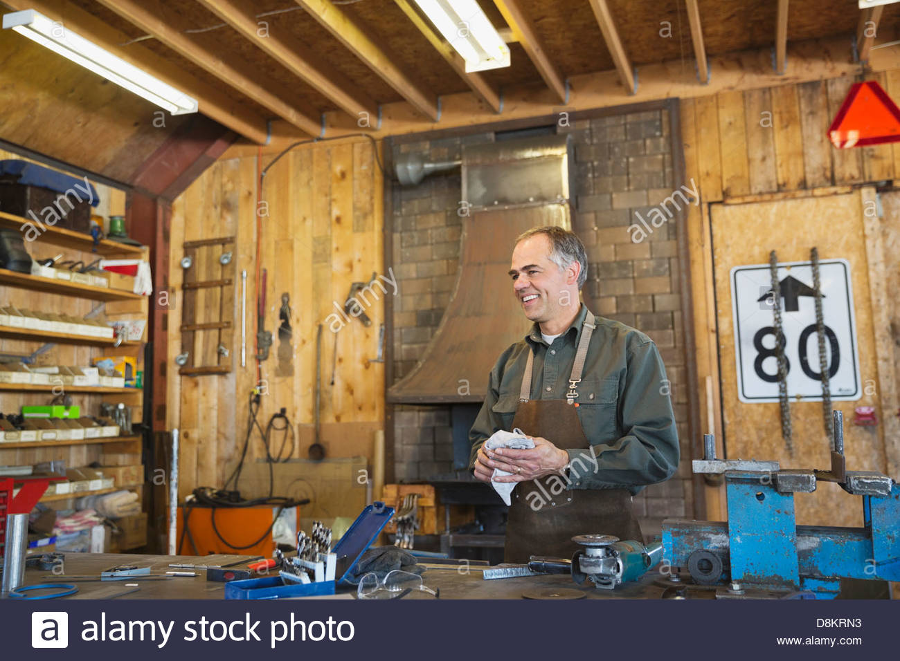 Metalworker cleaning up at workbench Stock Photo