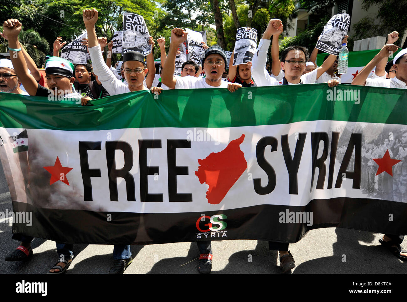 Kuala Lumpur, Malaysia. May 31, 2013. Demonstrators hold a banner as they march during a rally against Syria's President Bashar al-Assad and foreign intervention in Syrian crisis, outside the Iran embassy in Kuala Lumpur. Credit:  ZUMA Press, Inc./Alamy Live News Stock Photo