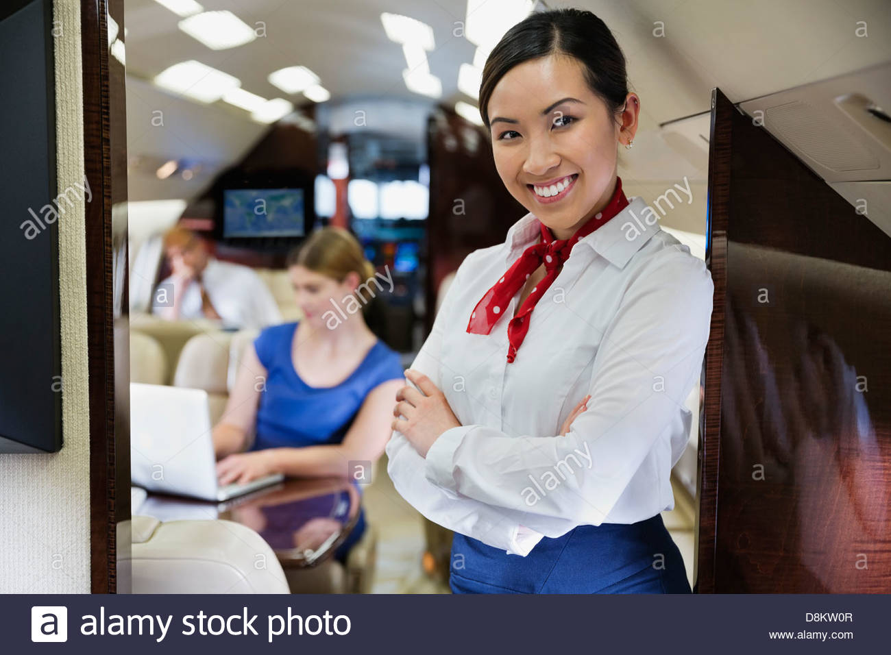 Portrait of flight attendant standing with arms crossed in airplane Stock Photo Alamy