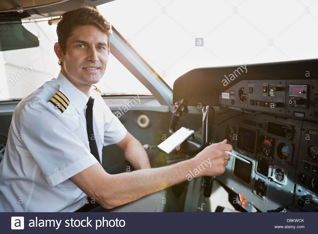 Portrait of male pilot sitting in airplane cockpit Stock Photo