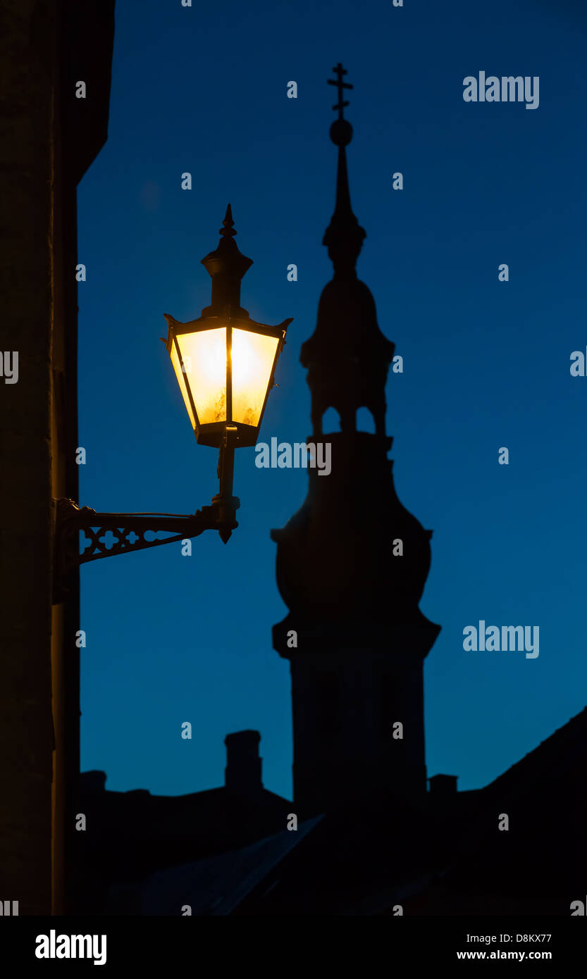 Old street lamp and church silhouette at night. Old town of Tallinn, Estonia Stock Photo