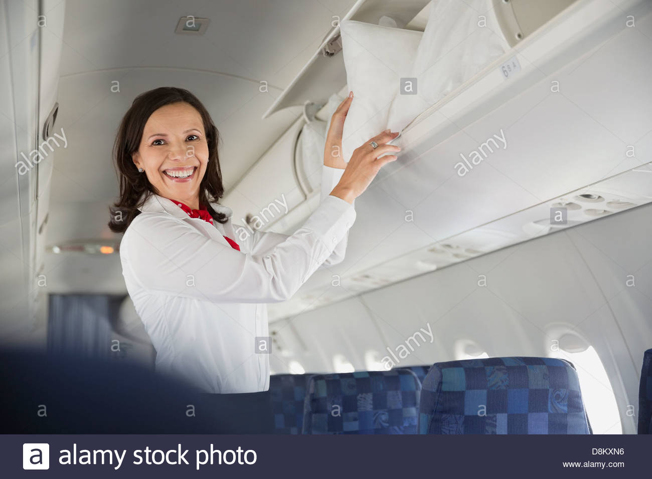 Flight attendant taking pillow out hires stock photography and images