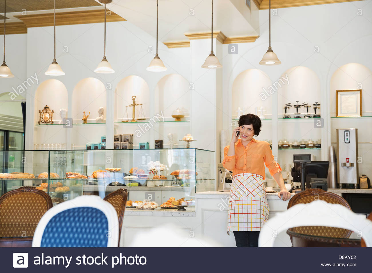 Female small business owner talking on mobile phone in coffee shop Stock Photo