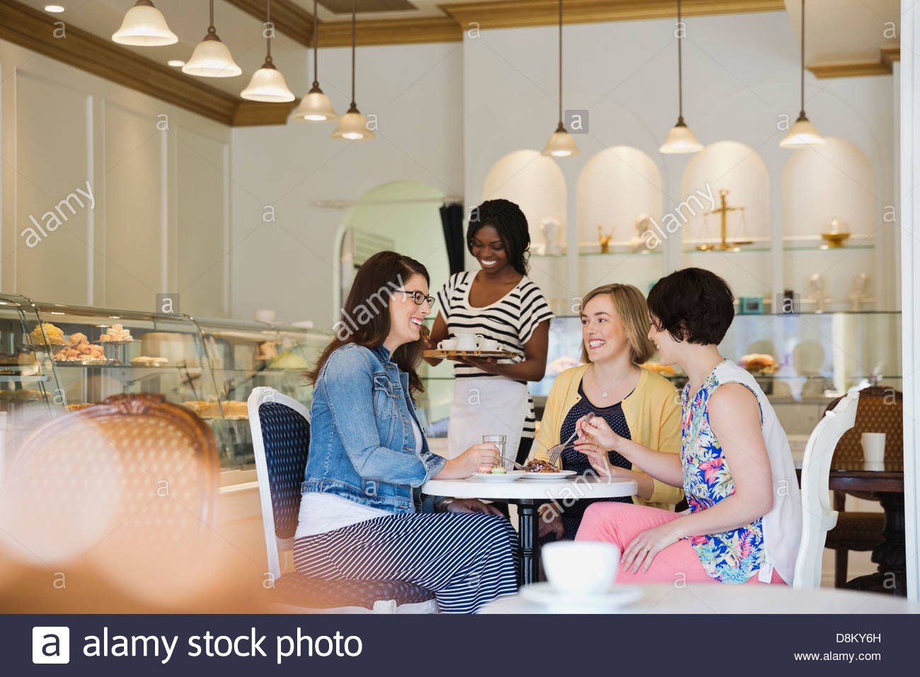 Group of women sharing dessert at coffee shop Stock Photo Alamy