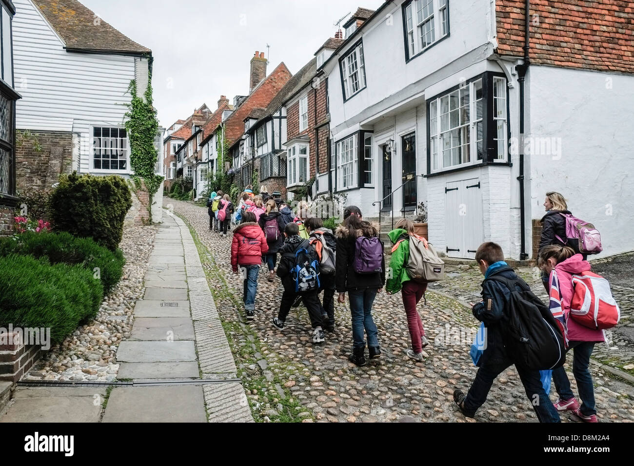 A group of primary school students walking up the historic Mermaid Street in Rye. Stock Photo