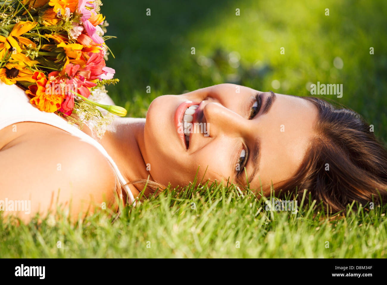 Beautiful young girl relaxing on green grass Stock Photo - Alamy