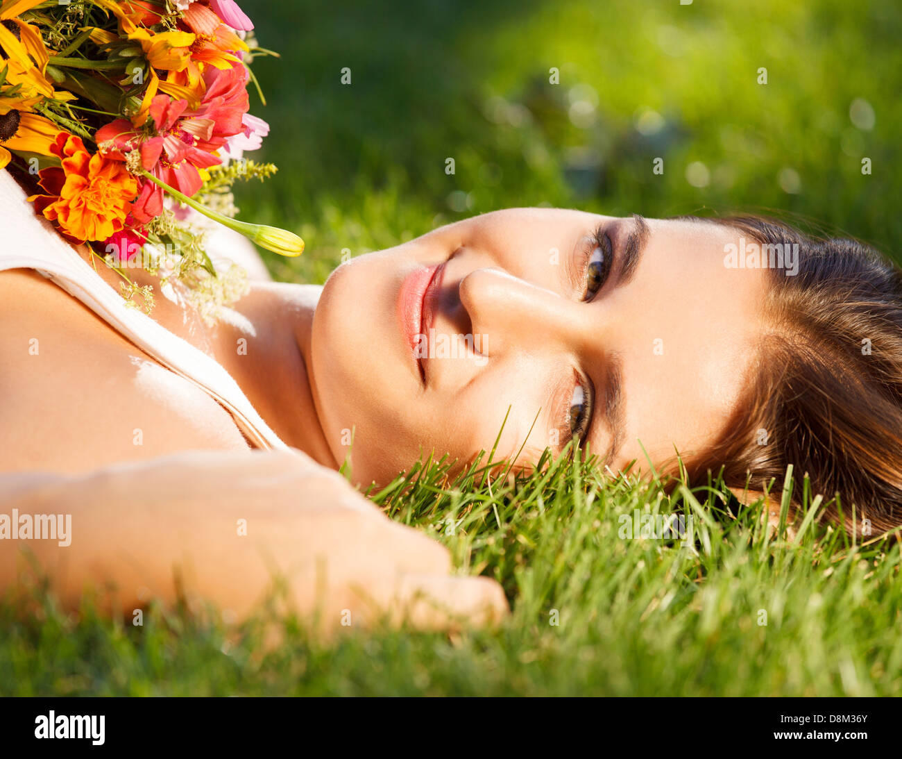 Beautiful young girl relaxing on green grass Stock Photo - Alamy