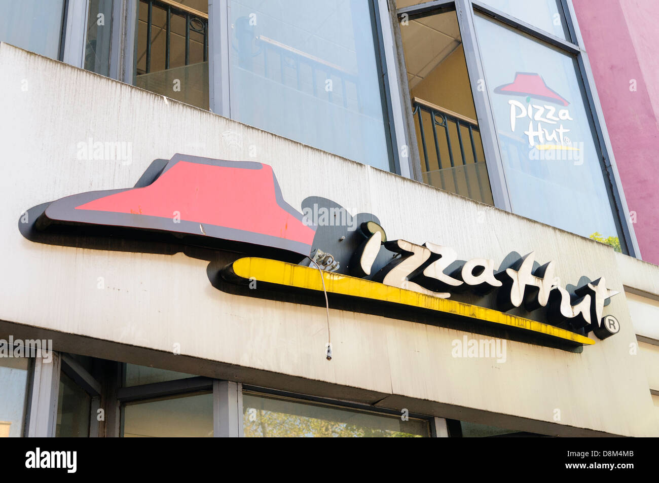 A broken sign on an abandoned, out of business, Pizza Hut Stock Photo