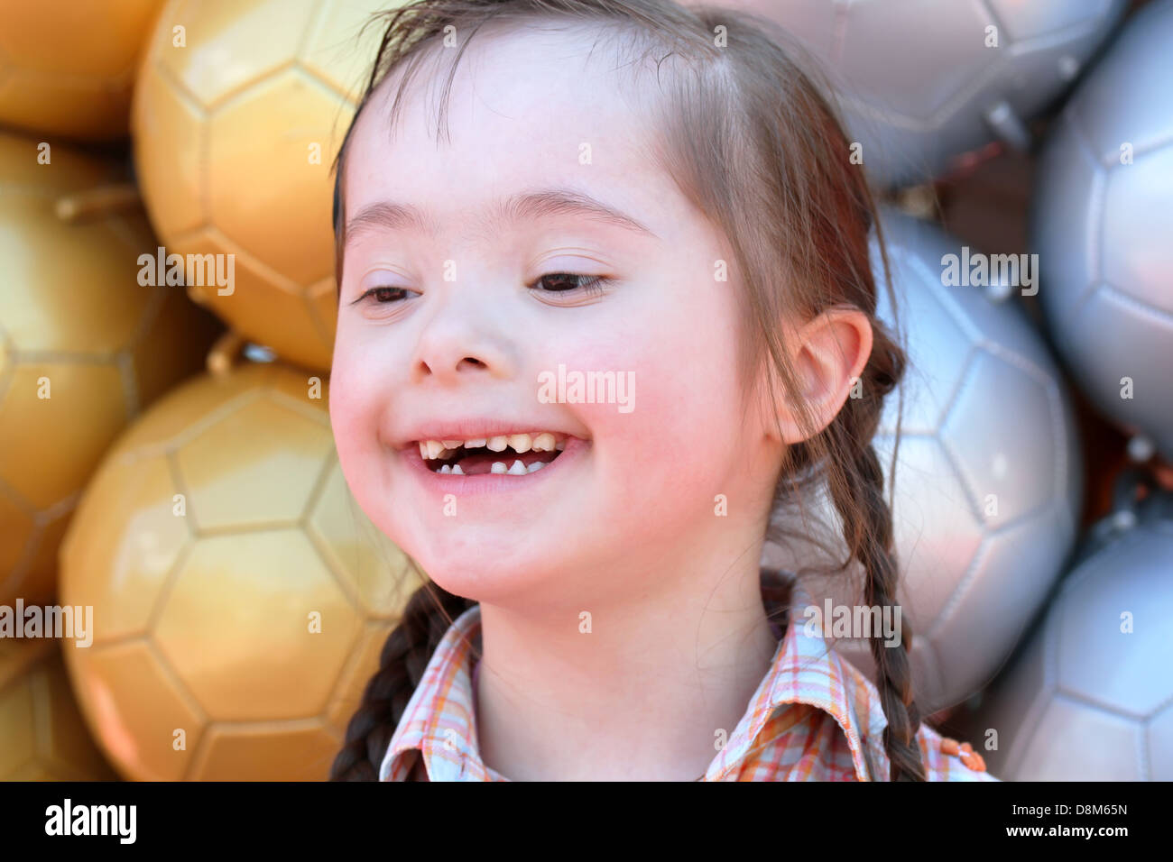 The little girl on the background of soccer balls. Stock Photo