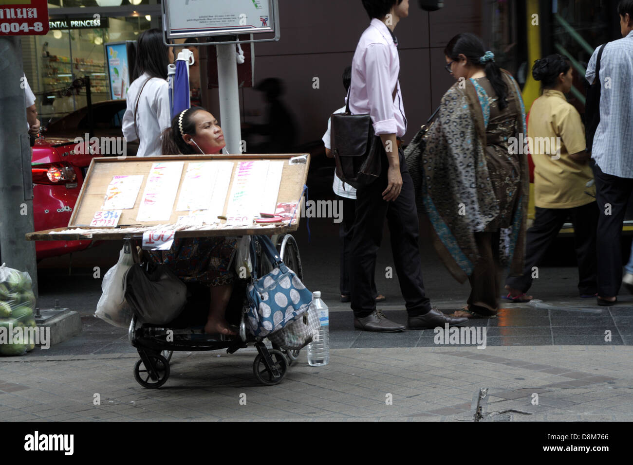 A disable Lottery ticket seller on Silom road in Bangkok , Thailand Stock Photo