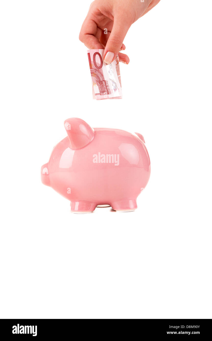 Female hand putting a coin into piggy bank Stock Photo - Alamy