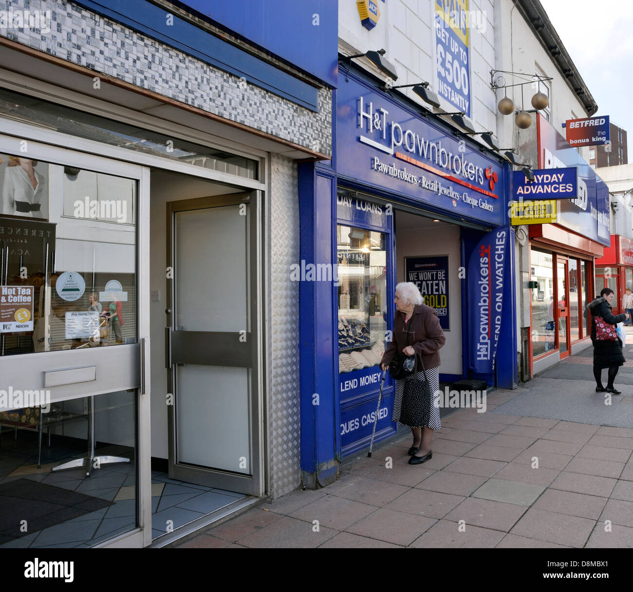 an elderly lady looks in a pawn brokers shop in stockport,greater manchester. Stock Photo