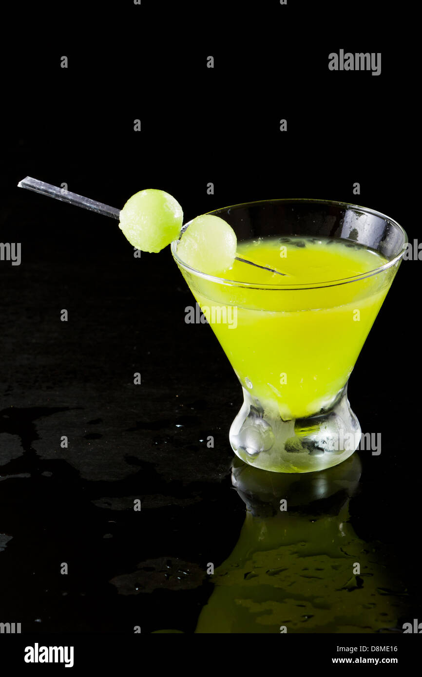 mellon ball cocktail served in a stemless martini glass isolated on a black background Stock Photo
