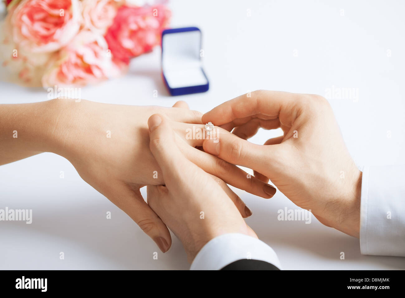 man putting  wedding ring on woman hand Stock Photo