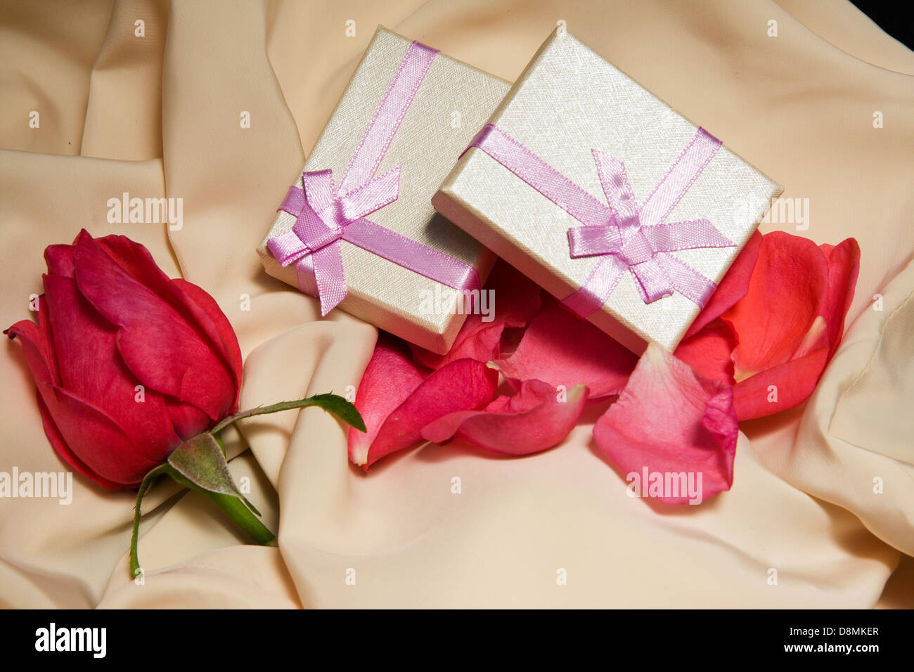 Gift Boxes over satin with rose arrangement. Stock Photo