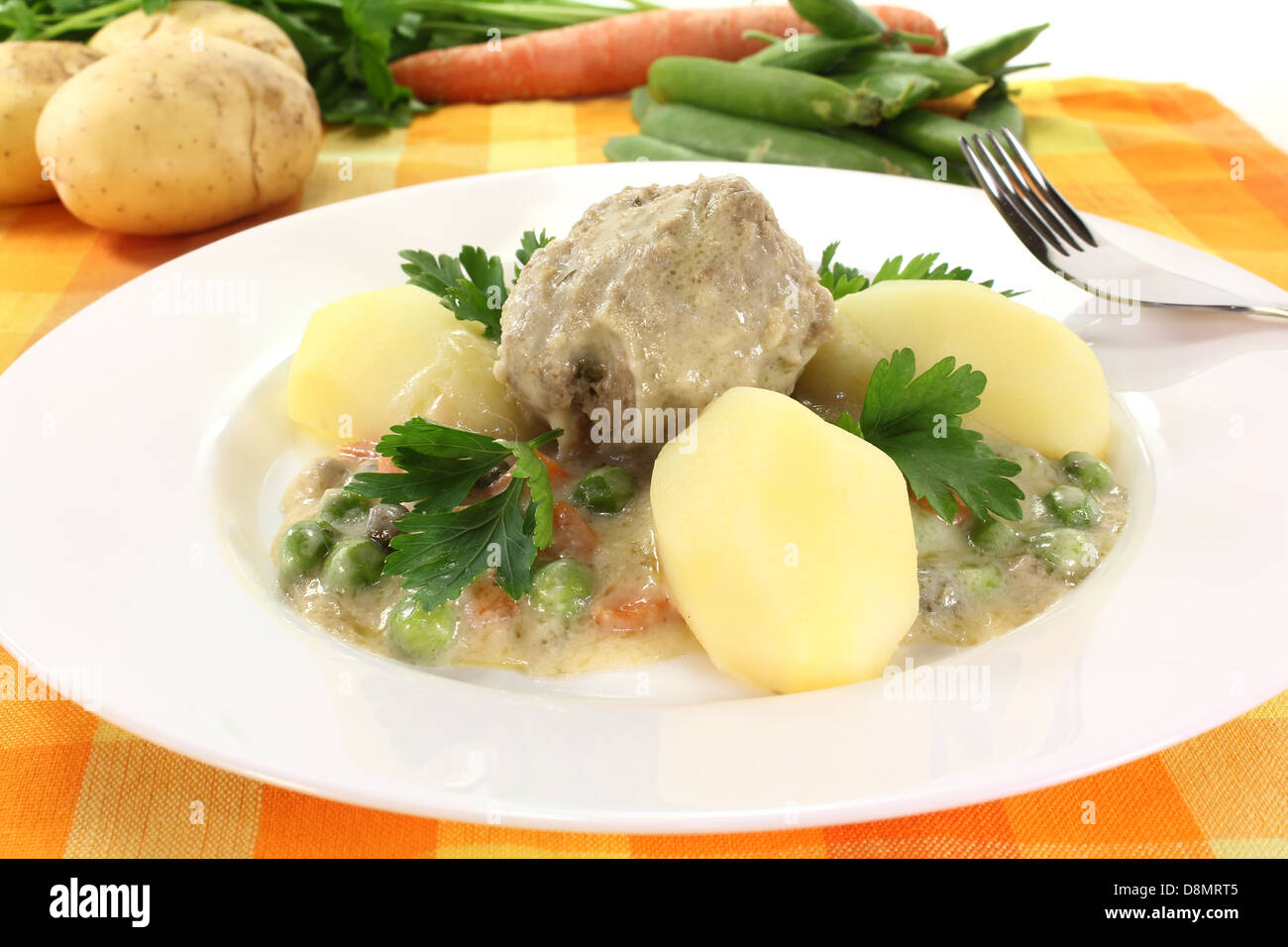 cooked meatballs in a white sauce with capers Stock Photo