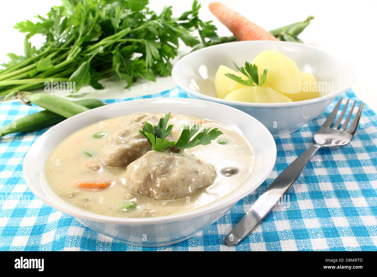 cooked meatballs in a white sauce with capers Stock Photo