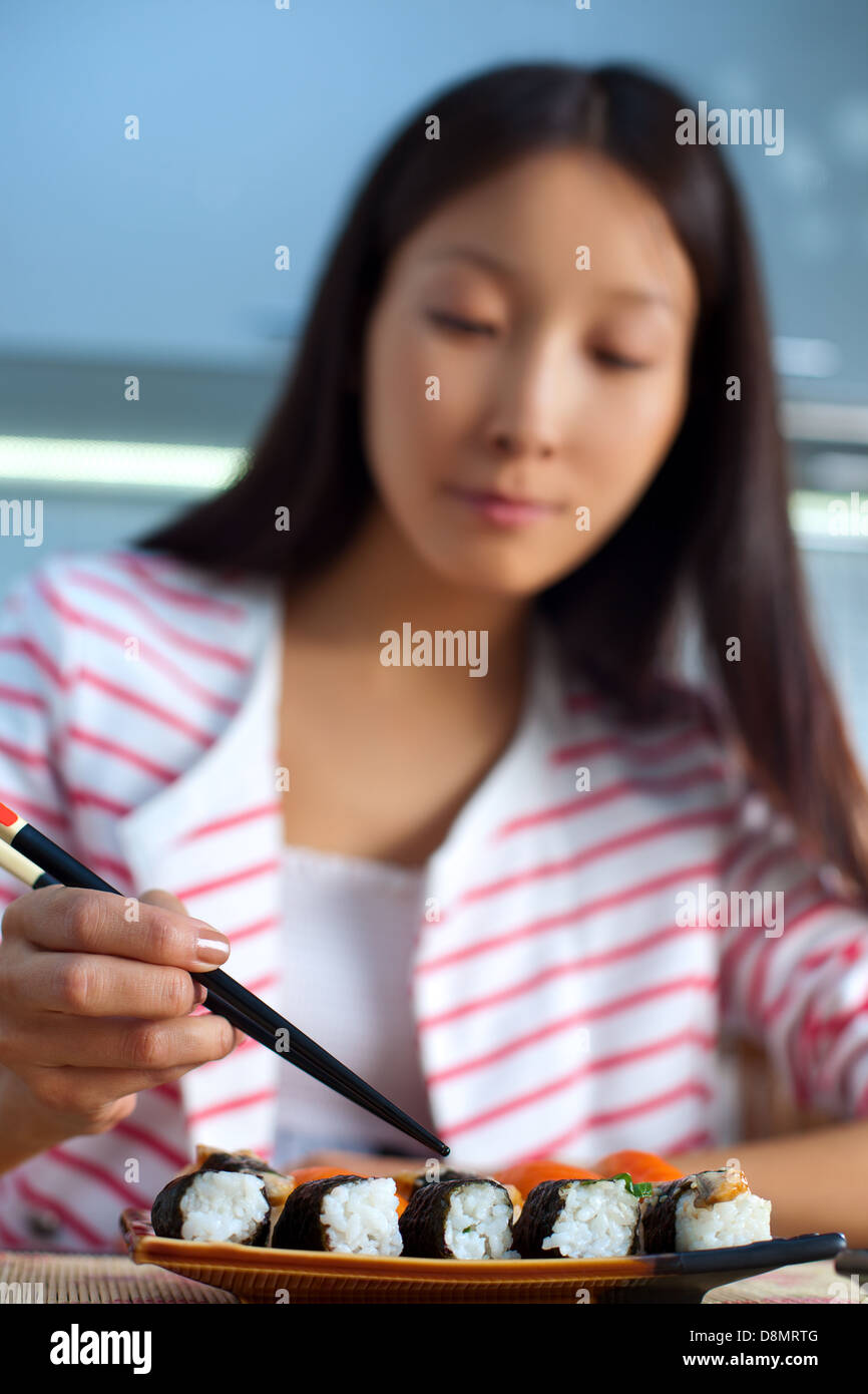 Young asian woman eating sushi. Focus on food Stock Photo Alamy