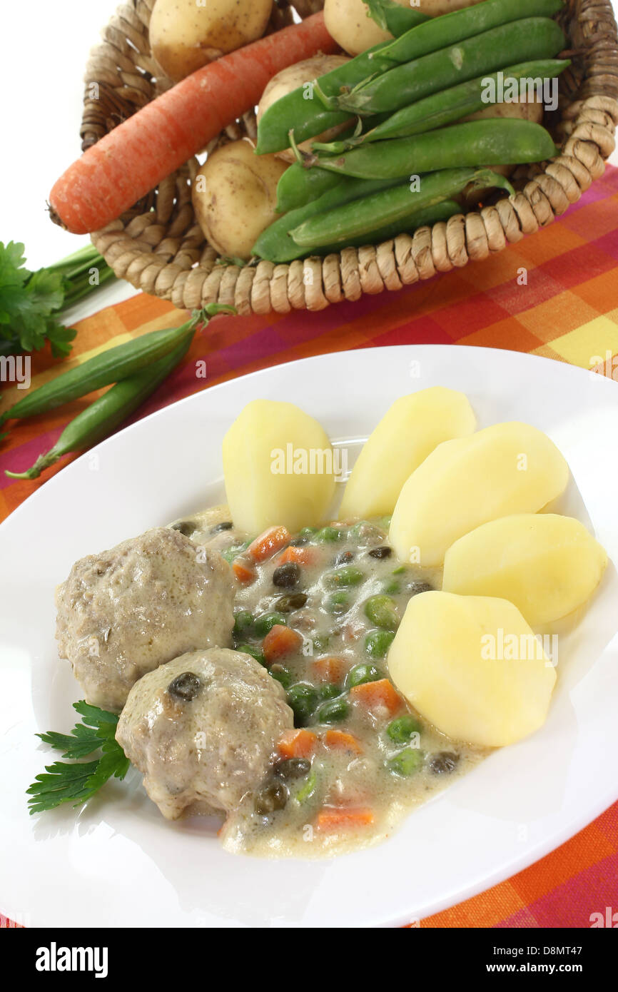 cooked meatballs in a white sauce with capers Stock Photo