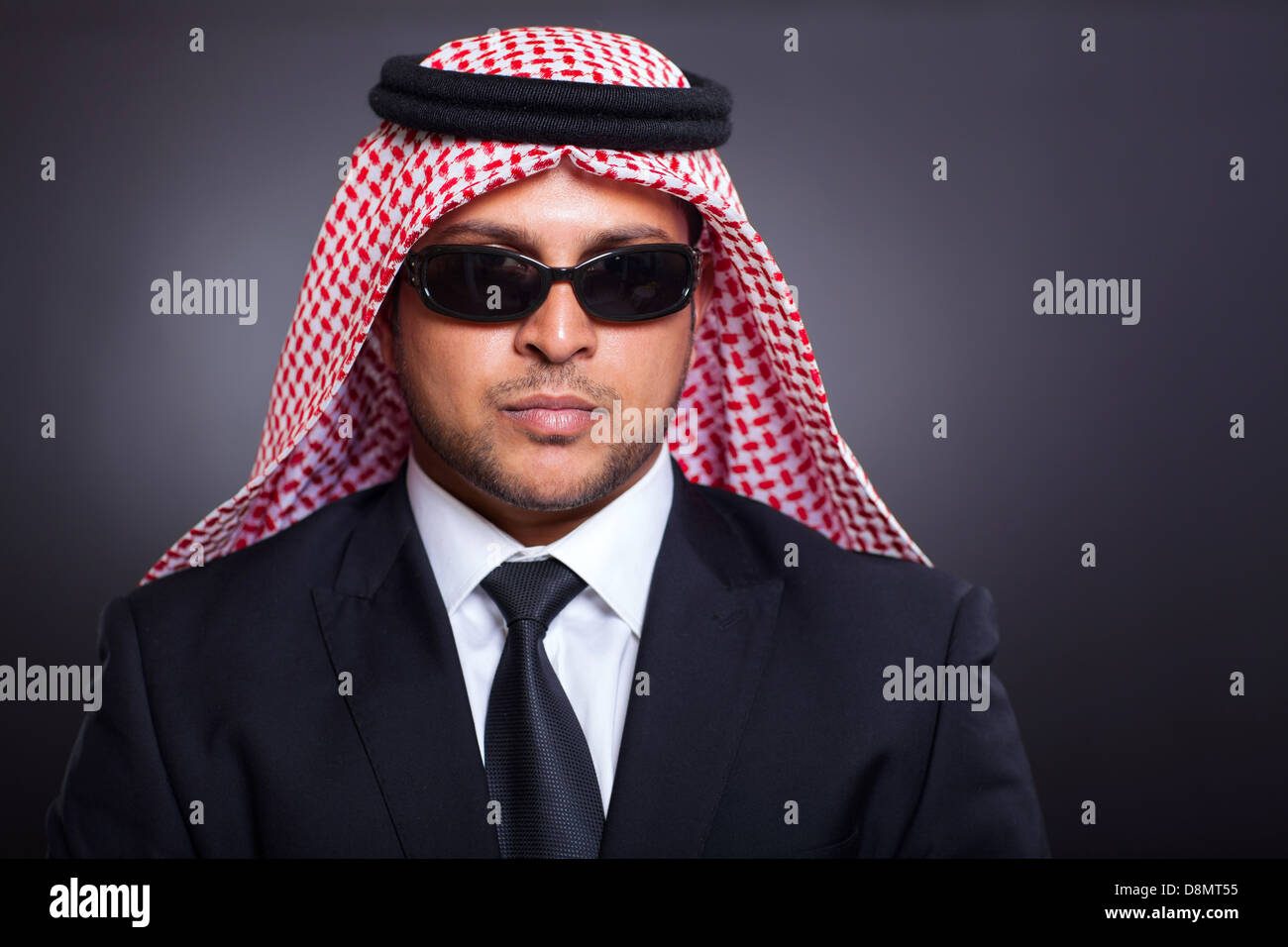wealthy arabian businessman wearing sunglasses on black background Stock Photo