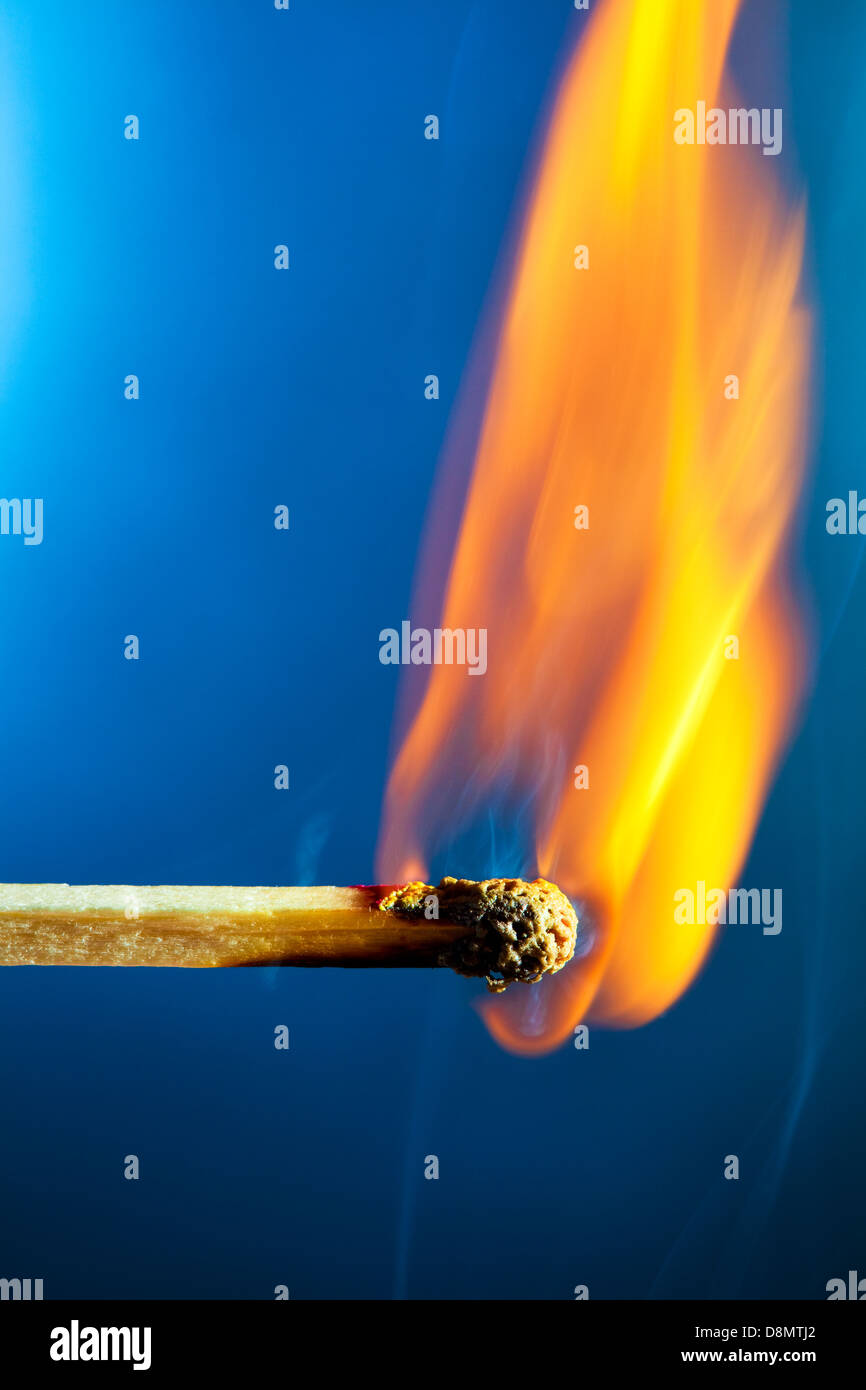 Burning match macro. On blue background. Stock Photo