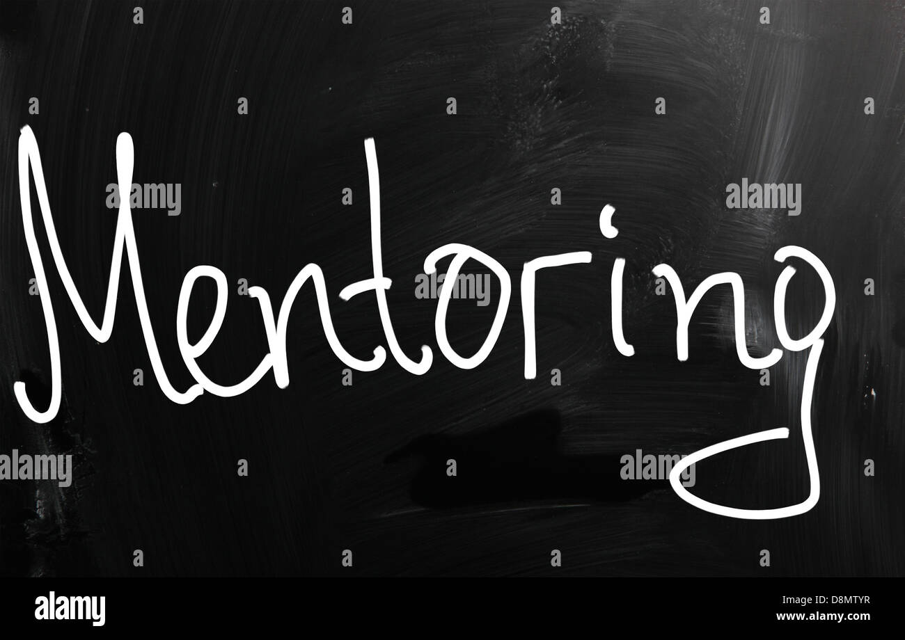 The word 'Mentoring' handwritten with white chalk on a blackboard Stock Photo