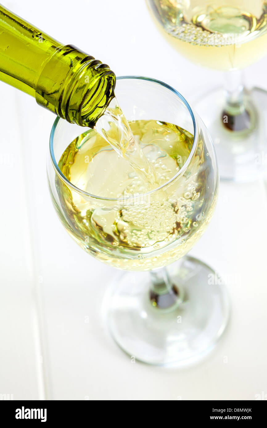 Glass of White Wine Being Poured - white wine being poured into a glass, looking down. Semi sparkling moscato, Australian wine. Stock Photo