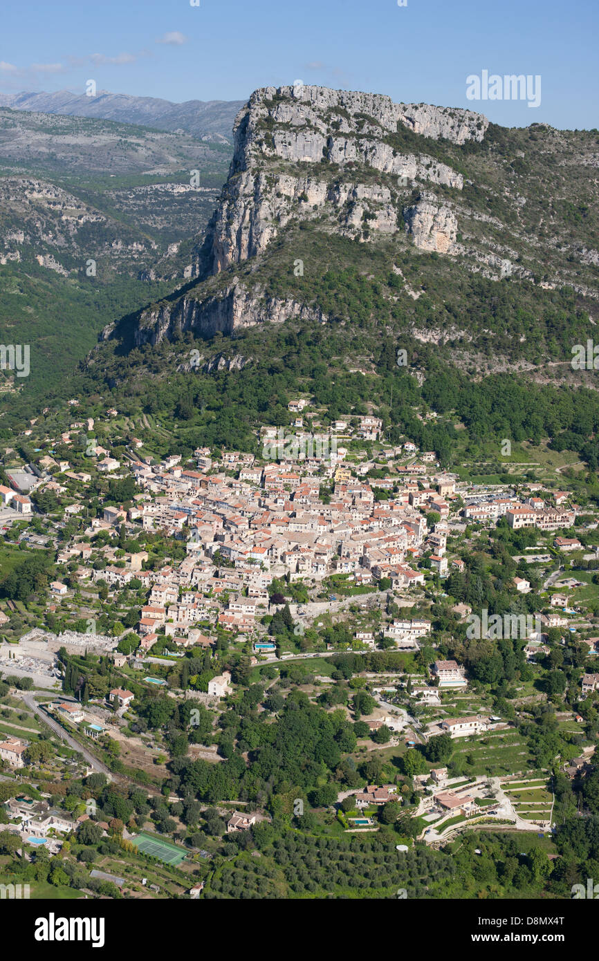 AERIAL VIEW. Medieval village at the foot of a massive 400-meter-high cliff. Saint-Jeannet, French Riviera, Alpes-Maritimes, France. Stock Photo