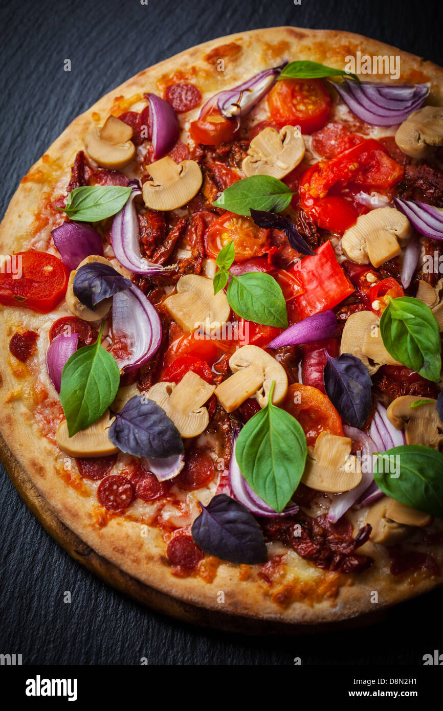 Homemade pizza with dried tomatoes and salami Stock Photo Alamy