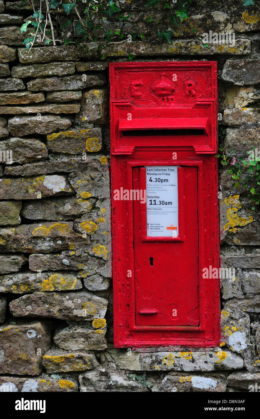 A red letterbox in a stone wall in the Cotswolds Stock Photo