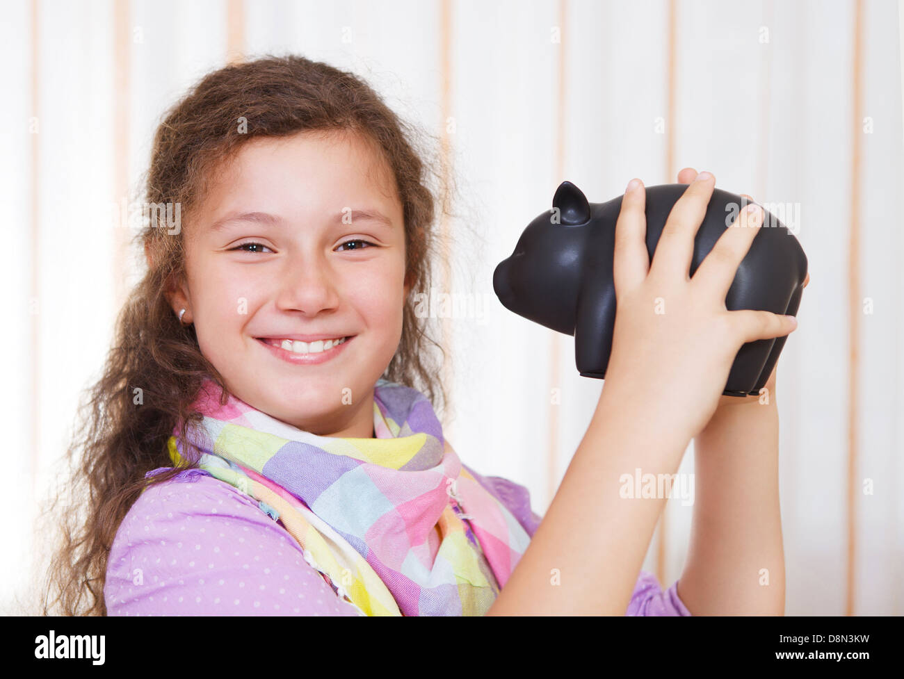 Little girl saving money in a piggybank Stock Photo - Alamy