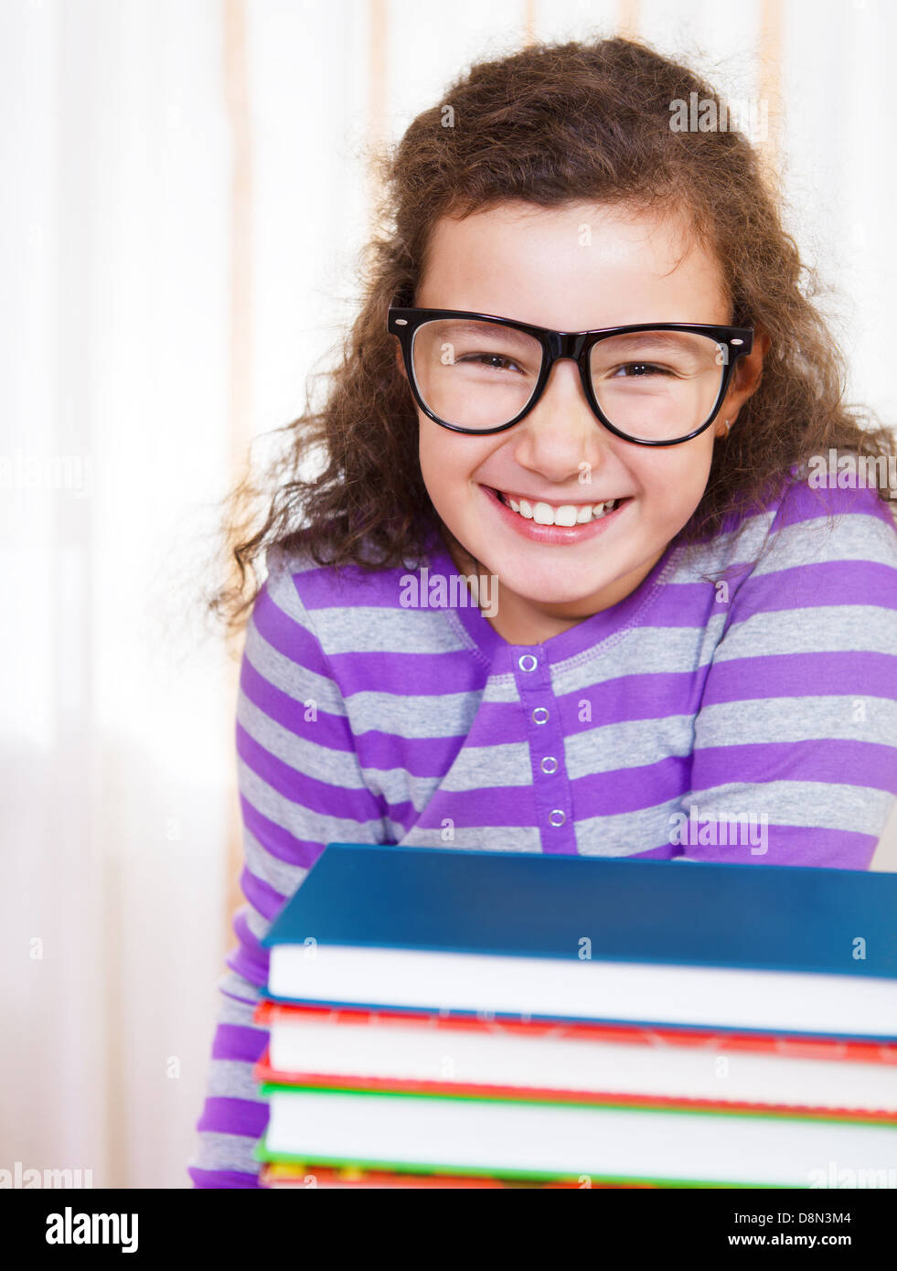 Little brunette smiling girl with books Stock Photo - Alamy