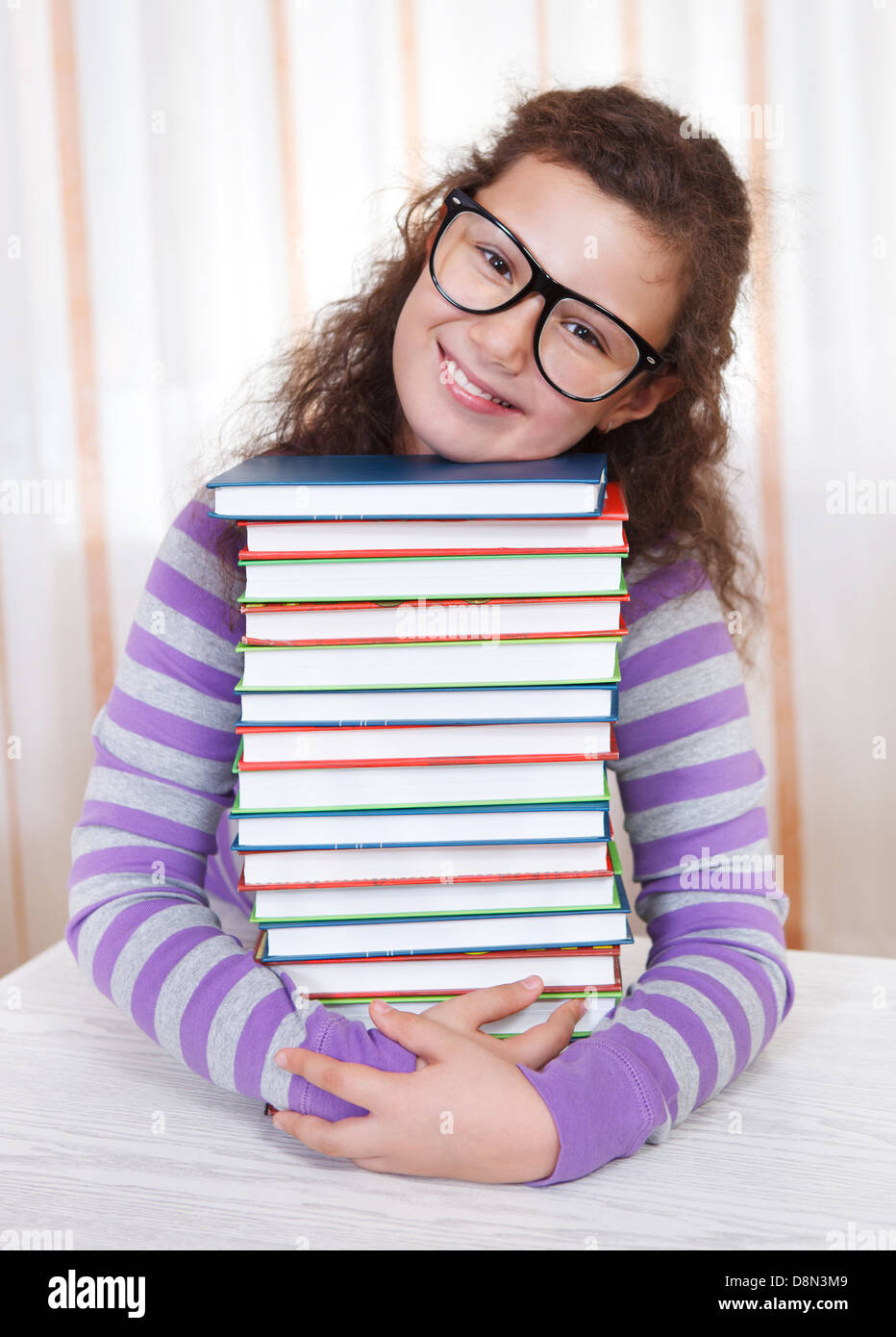 Little brunette smiling girl with books Stock Photo - Alamy