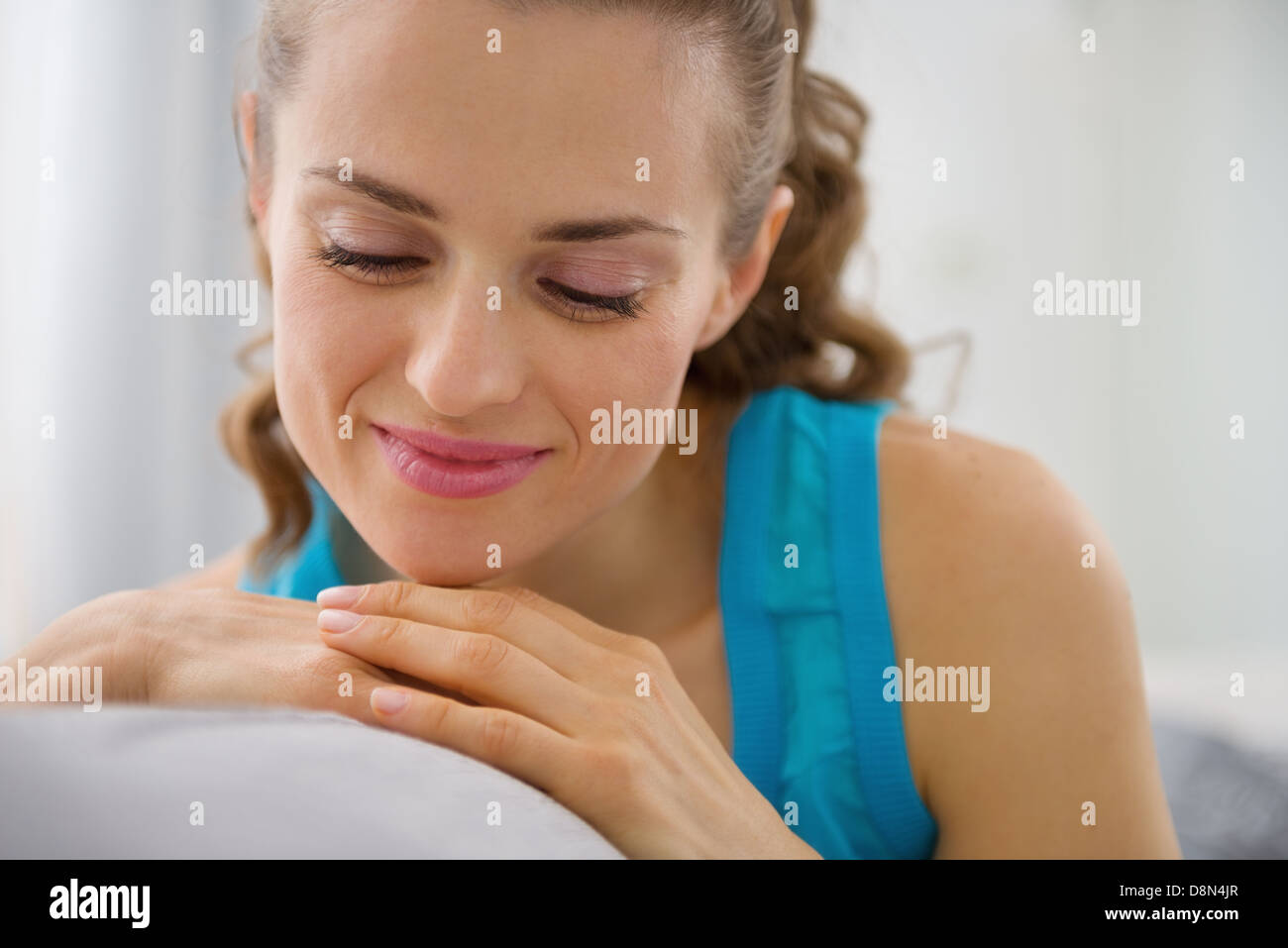 Portrait of happy young woman sitting on sofa in living room Stock ...
