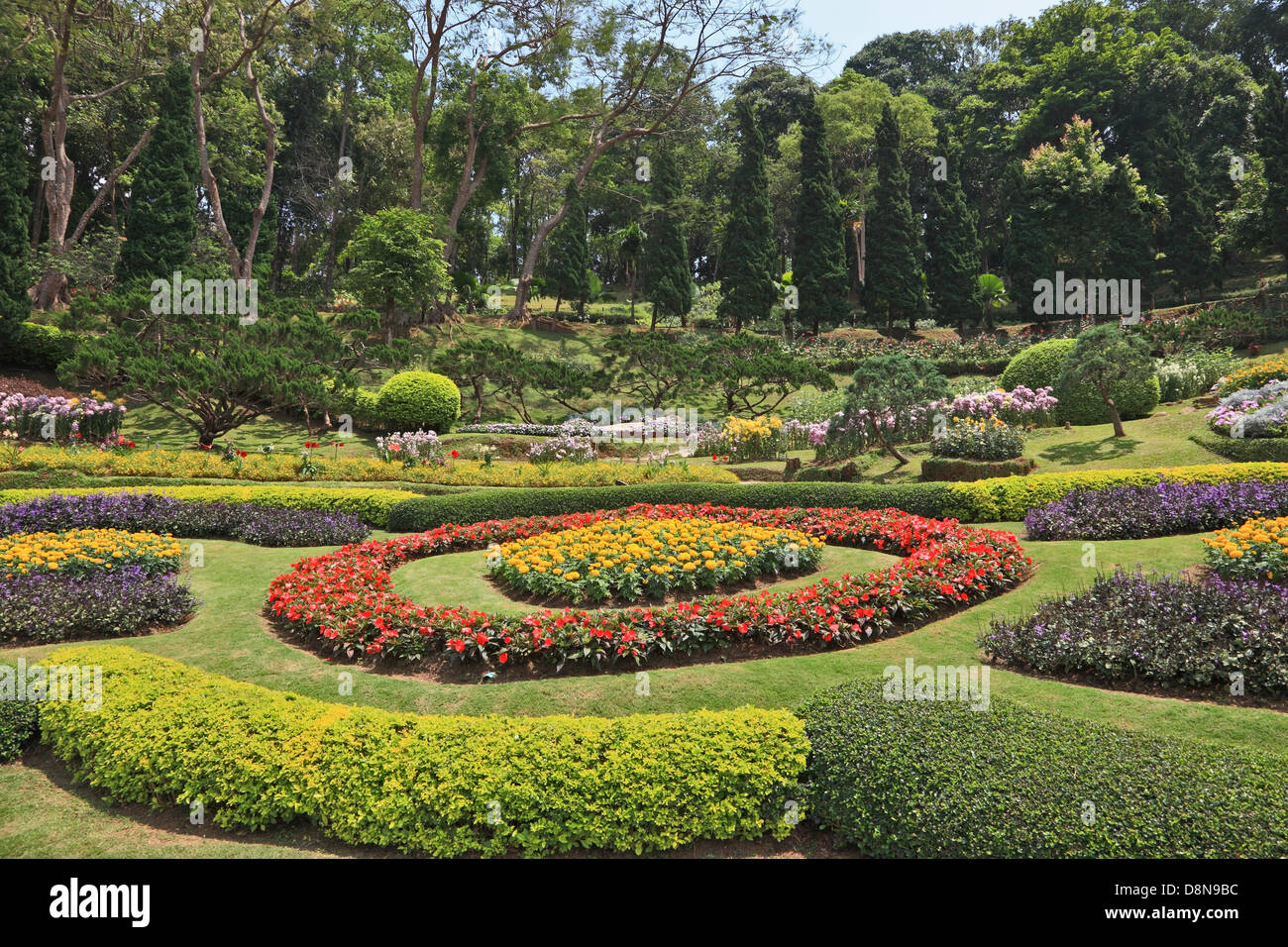 Acacias and artly decorated flower beds Stock Photo